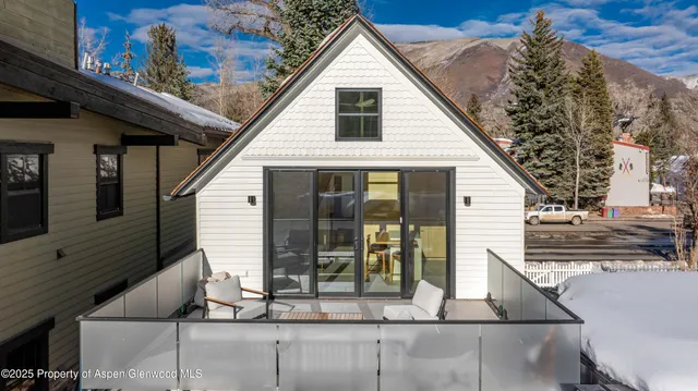 a view of a small house with roof deck front of house