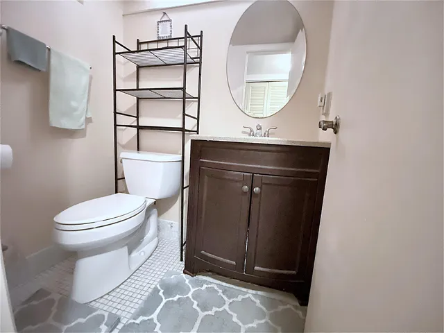 a bathroom with a sink vanity mirror and toilet