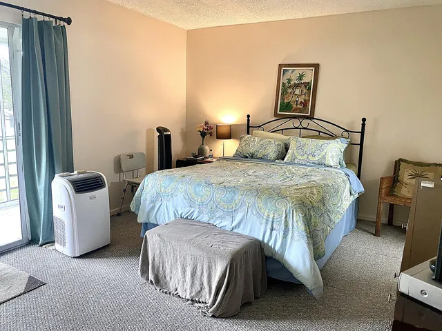 a bedroom with a bed dresser and a window