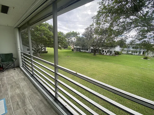 a view of a balcony with chairs and wooden floor