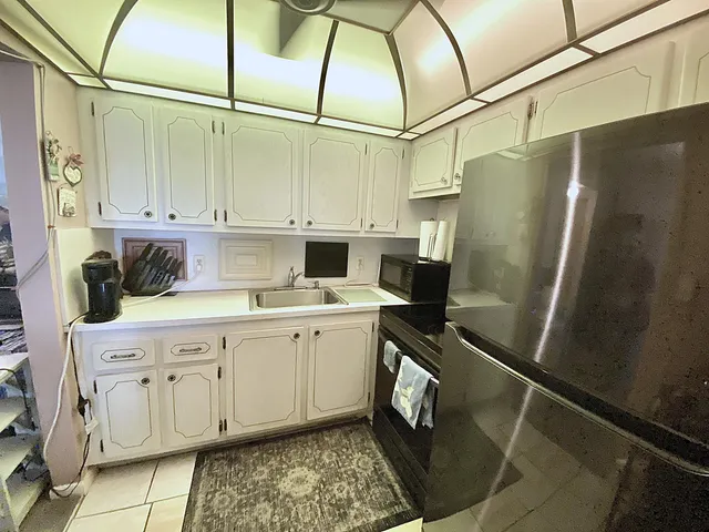 a kitchen with white cabinets and sink