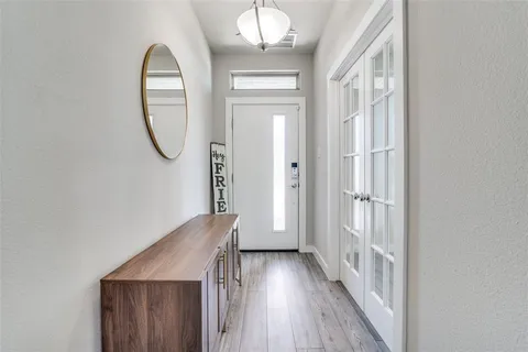 wooden floor in an entryway with a mirror