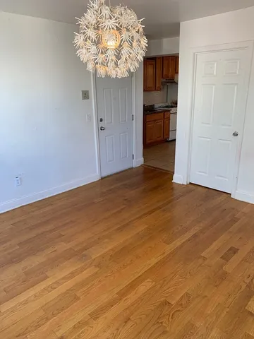 a view of a room with wooden floor and a window