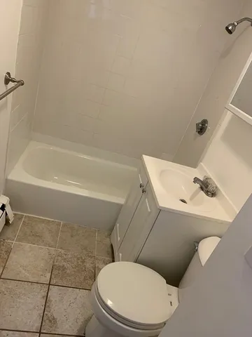 a white toilet and tub sitting next to a bathroom sink