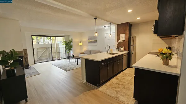 a large bedroom with furniture a large window and wooden floor