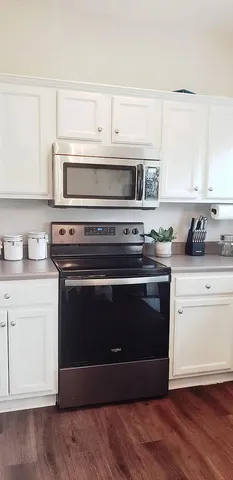 a kitchen with stainless steel appliances granite countertop a stove microwave and sink