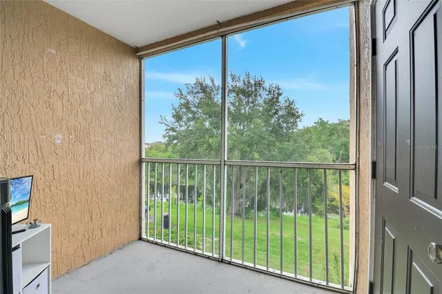 a view of a balcony with green trees