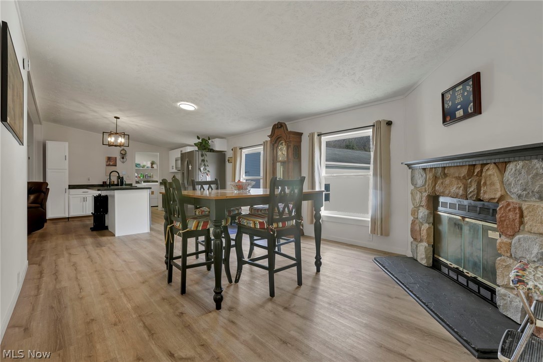 3750 Cannelville Road Roseville, OH 43777 - Photo 14 of 33 Dining space featuring healthy amount of natural light, light wood-type flooring, and a fireplace