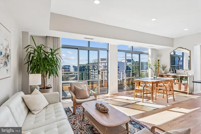 a dining room with furniture and large windows