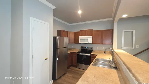 a view of a hallway with wooden floor and closet