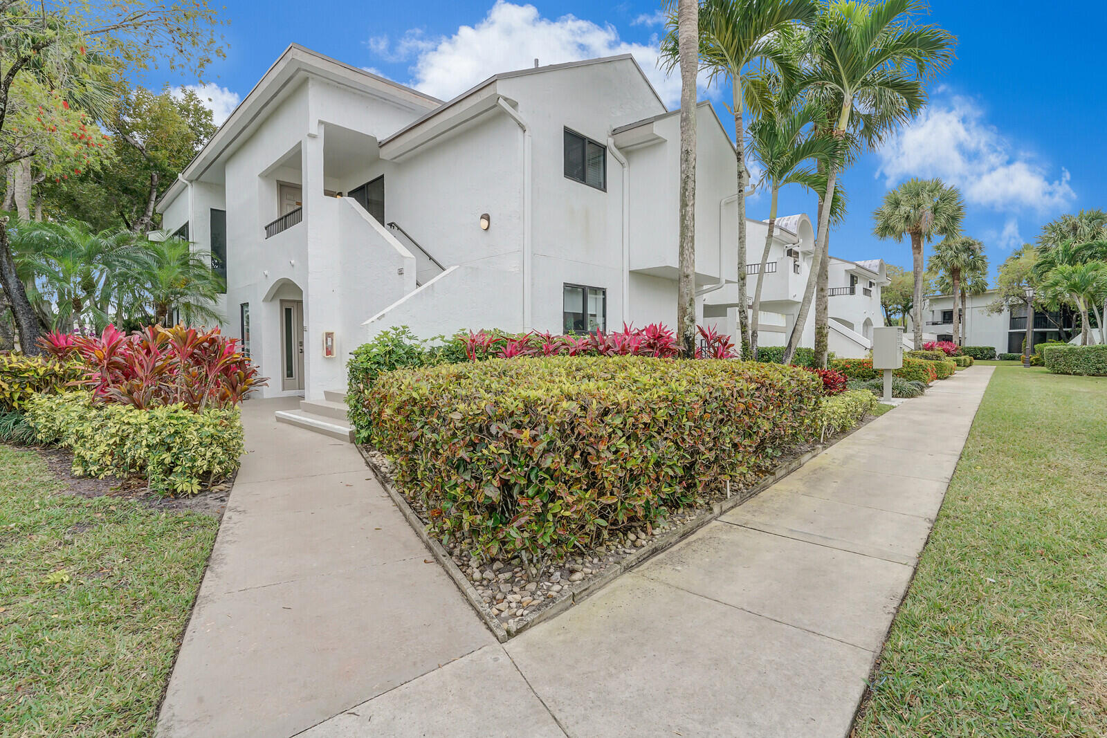 7527 Glendevon Lane, Unit 805 Delray Beach, FL 33446 - Photo 35 of 52 a front view of a house with a yard and potted plants