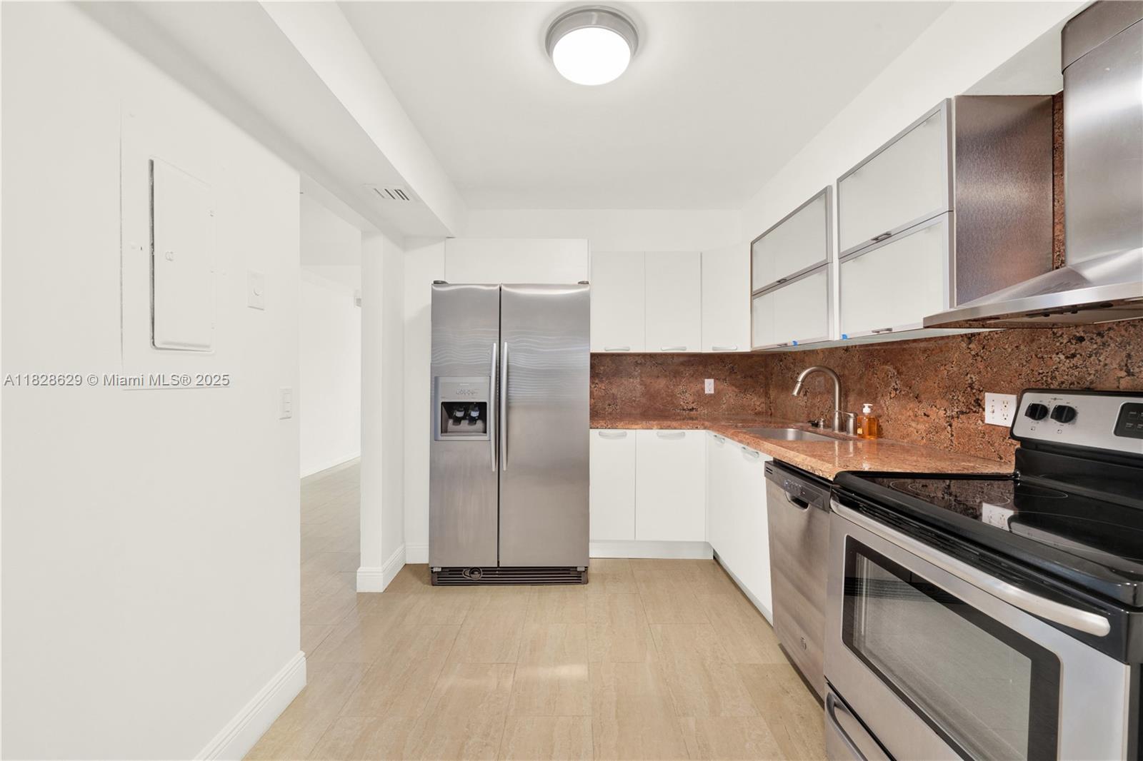 3200 North Course Lane, Unit 216 Pompano Beach, FL 33069 - Photo 13 of 36 a kitchen with stainless steel appliances granite countertop a refrigerator and a sink