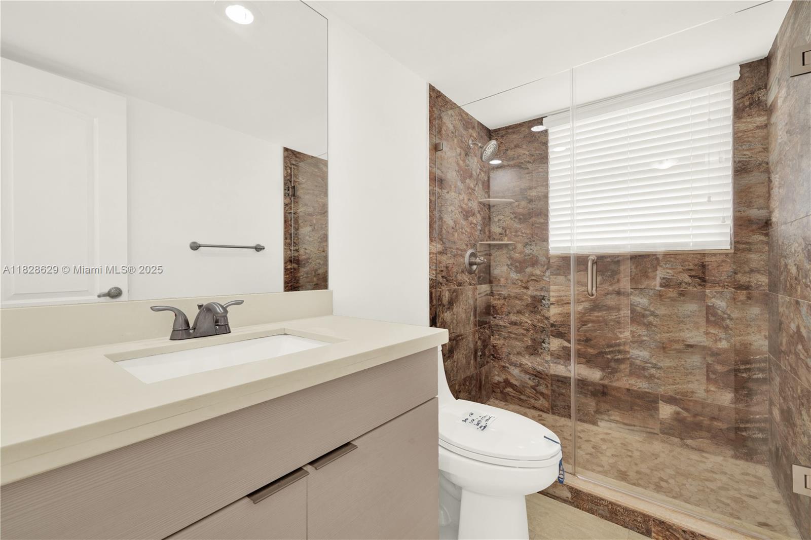 3200 North Course Lane, Unit 216 Pompano Beach, FL 33069 - Photo 25 of 36 a bathroom with a sink toilet and a mirror