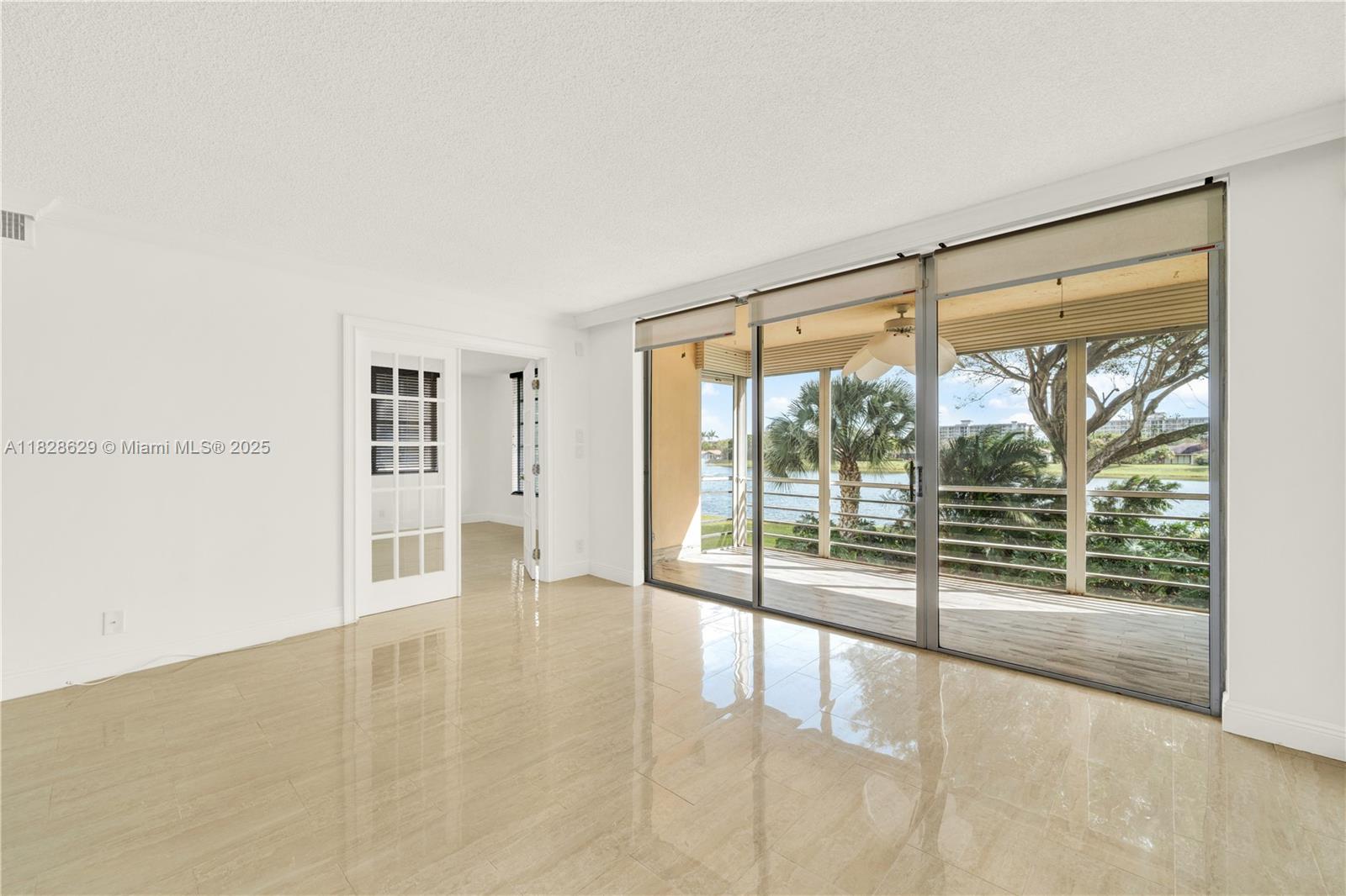 3200 North Course Lane, Unit 216 Pompano Beach, FL 33069 - Photo 6 of 36 an empty room with floor to ceiling windows and pool table