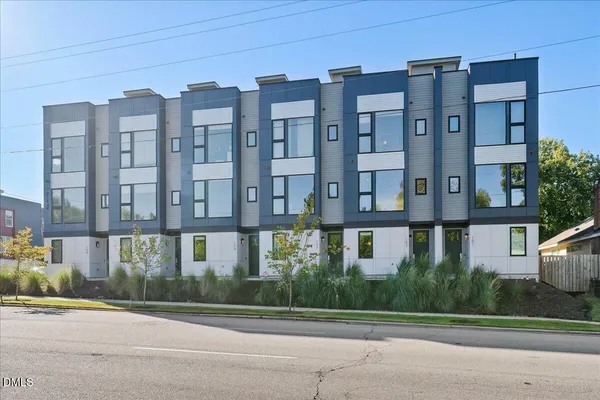 a front view of a residential apartment building with a yard