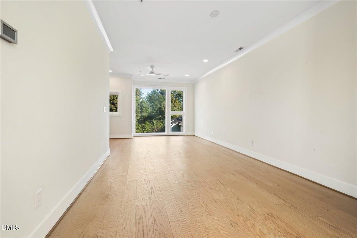 712 East Edenton Street, Unit 102 Raleigh, NC 27601 - Photo 7 of 29 an empty room with wooden floor and windows