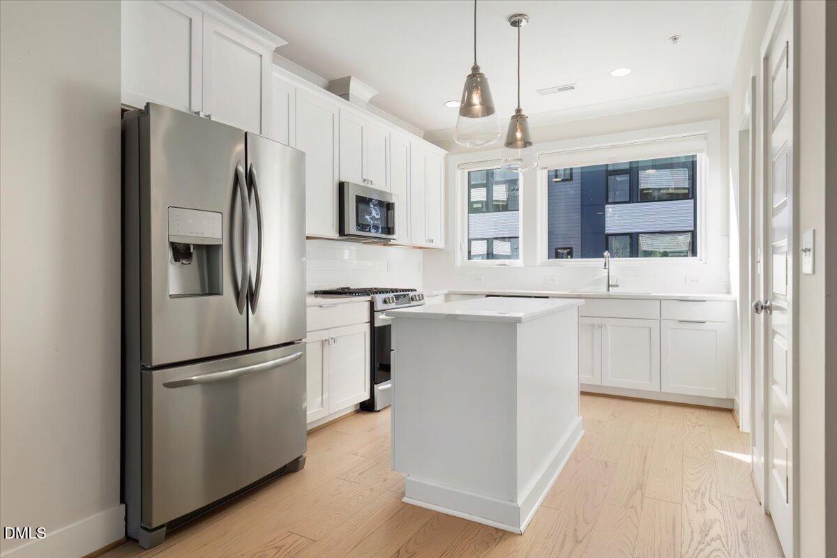 712 East Edenton Street, Unit 102 Raleigh, NC 27601 - Photo 9 of 29 a kitchen with stainless steel appliances a refrigerator sink and microwave