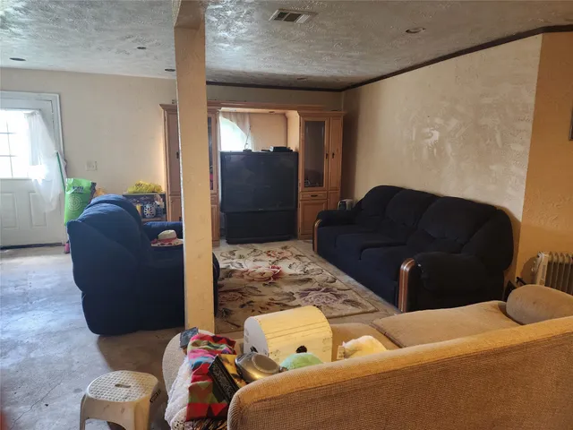 a living room with furniture and a air conditioner vent