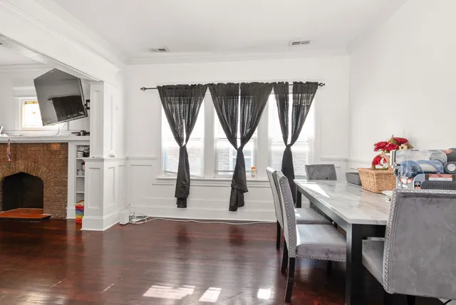 a dining room with furniture window and wooden floor