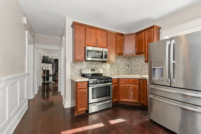 a kitchen with stainless steel appliances granite countertop a refrigerator stove and sink