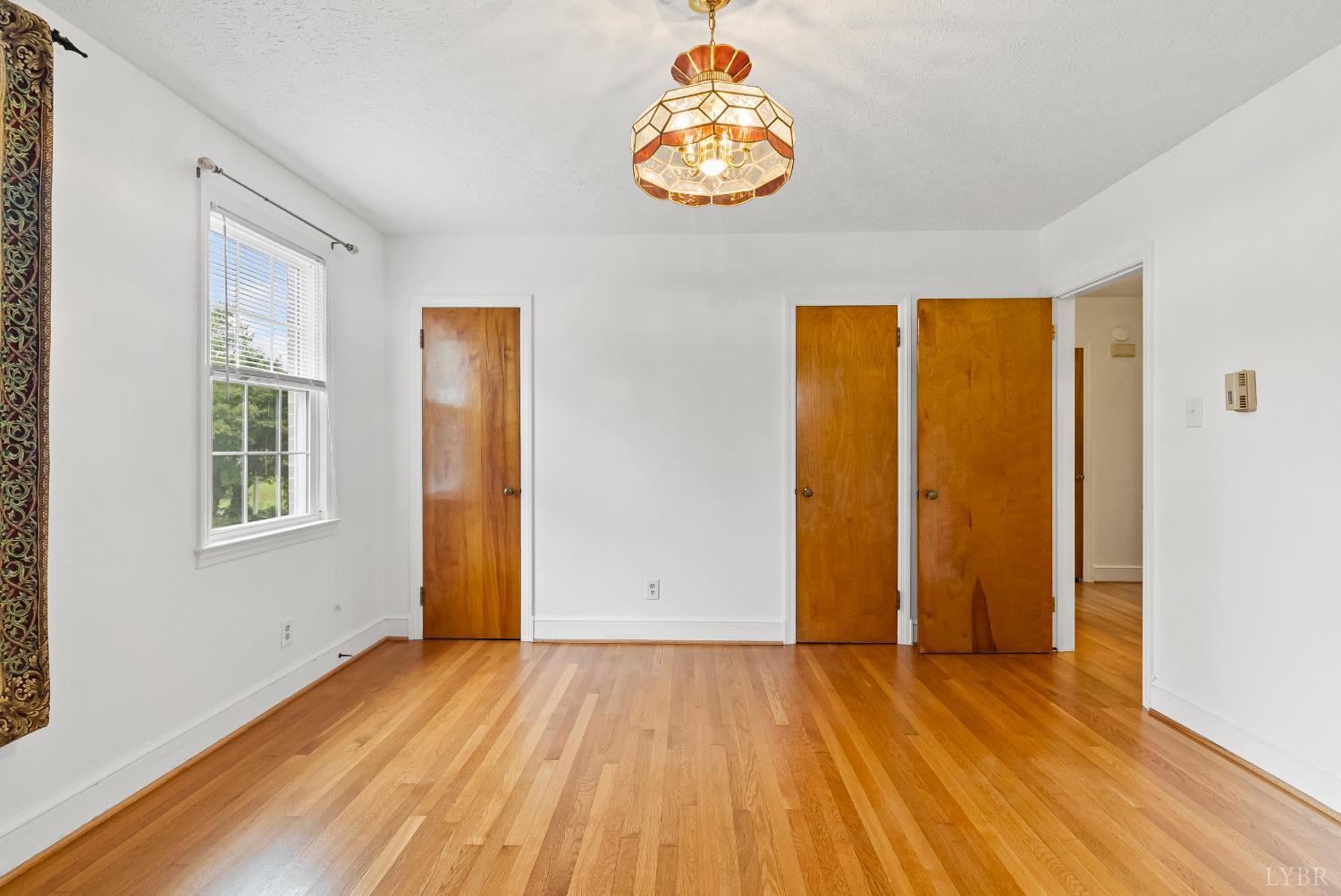 302 Henry Street Gretna, VA 24557 - Photo 17 of 49 a view of an empty room with wooden floor and a window