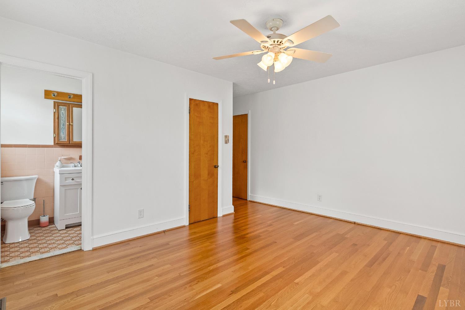 302 Henry Street Gretna, VA 24557 - Photo 20 of 49 a view of a room with wooden floor and a ceiling fan