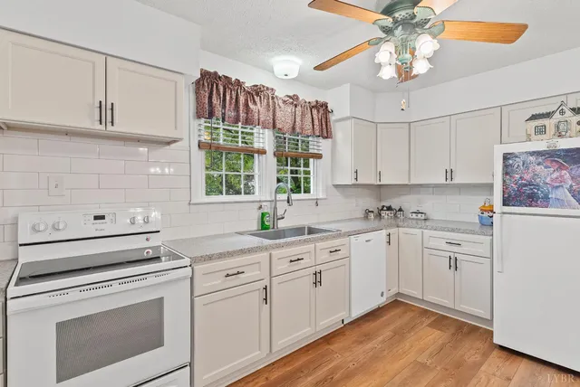 a kitchen with cabinets appliances a sink and a counter top space