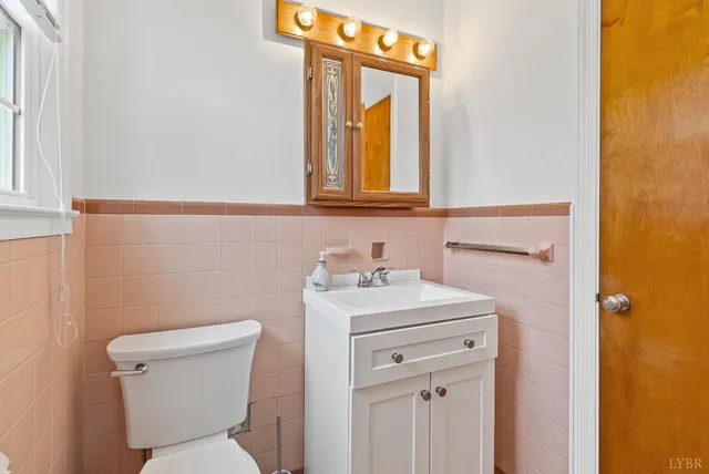 a bathroom with a toilet sink vanity and mirror