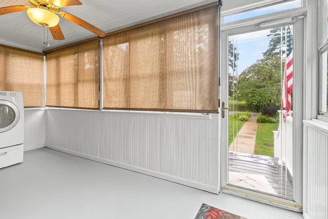 a view of an empty room with a window and a ceiling fan