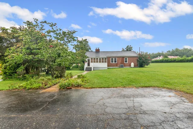 a view of a house with a yard and potted plants