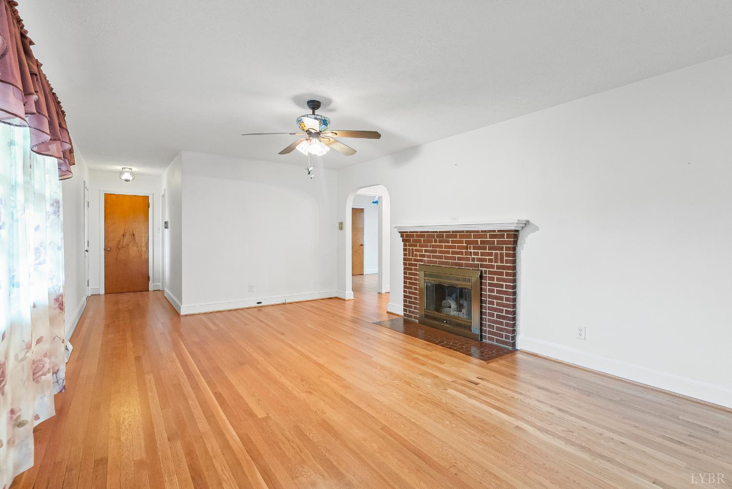 302 Henry Street Gretna, VA 24557 - Photo 4 of 49 a view of an empty room with wooden floor fireplace and a window