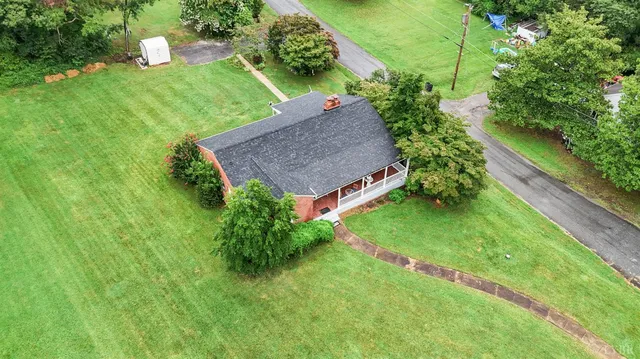 a aerial view of a house with a yard and trees