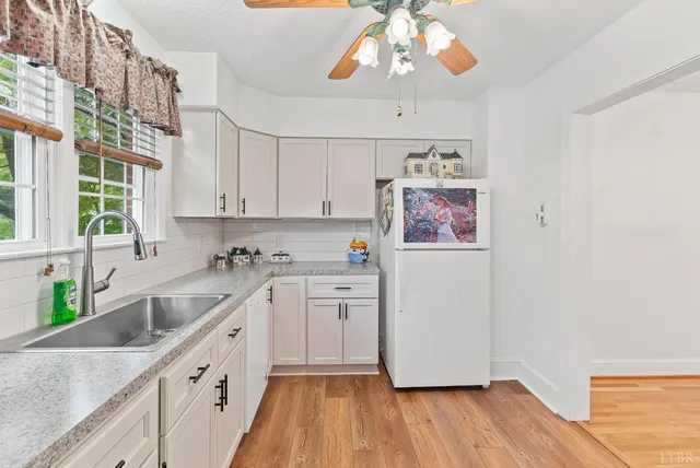 a kitchen with a refrigerator a sink and dishwasher with wooden floor