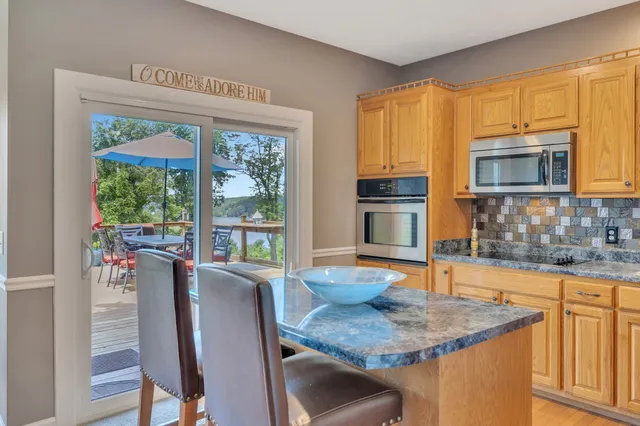 a kitchen with stainless steel appliances granite countertop a stove top oven a sink and a refrigerator