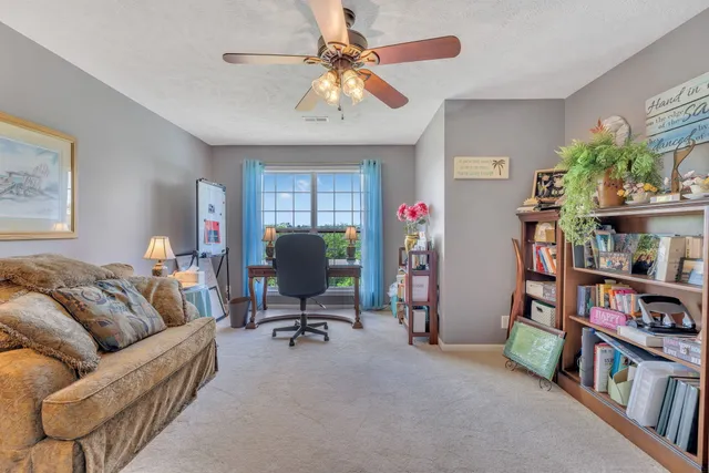 a living room with furniture and a book shelf