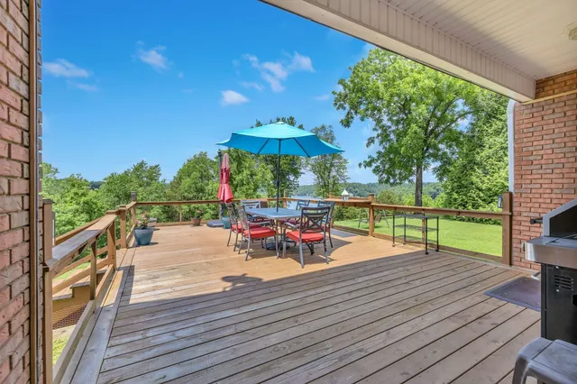 a patio with wooden floor a yard a table and chairs