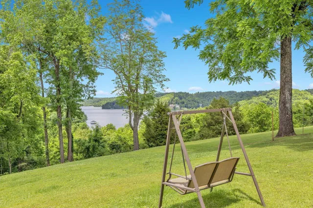 a white house with a big yard and large trees
