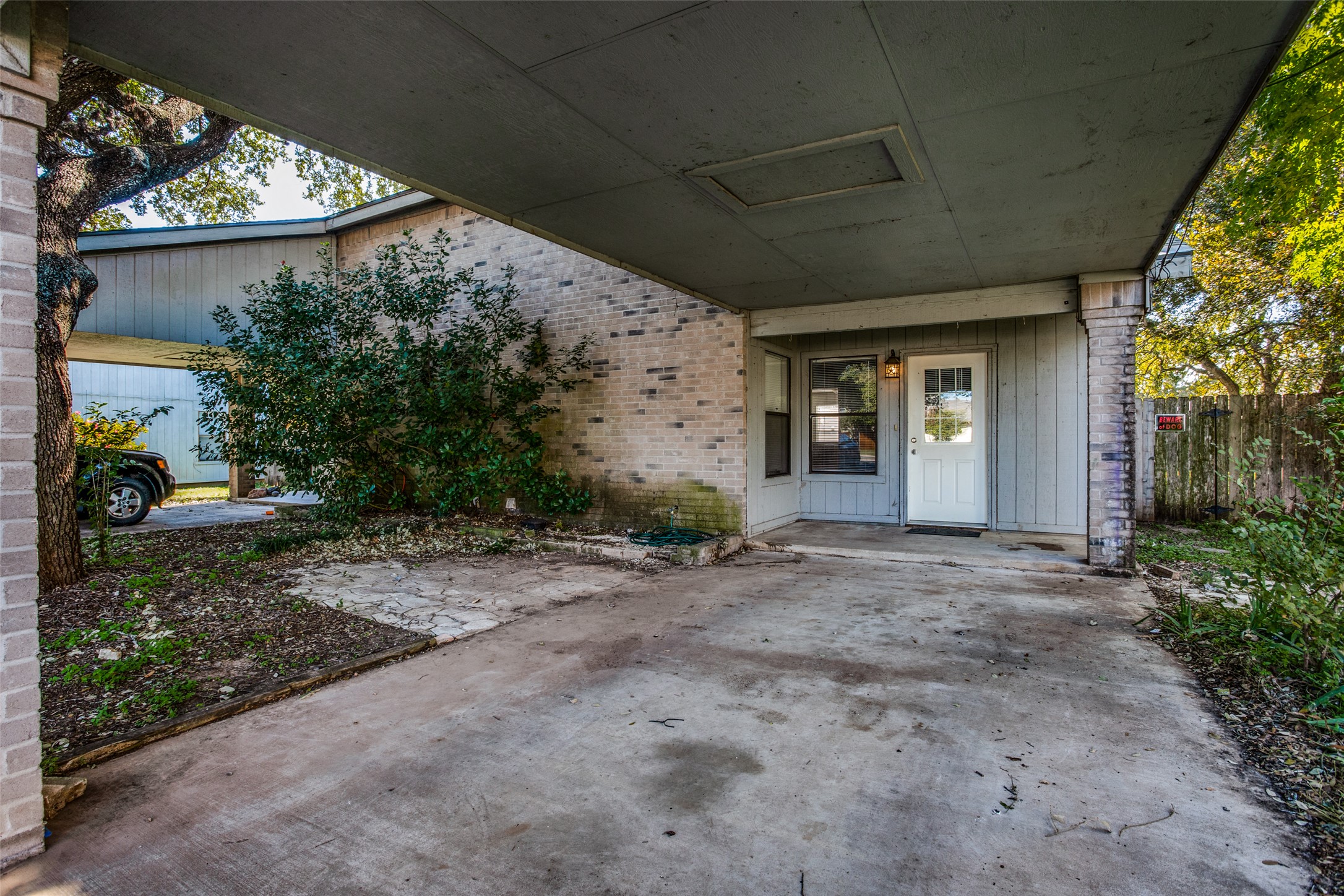 106 Verna Spur, Unit B Georgetown, TX 78628 - Photo 2 of 25 A convenient covered parking area leads to a welcoming entry with brick accents.