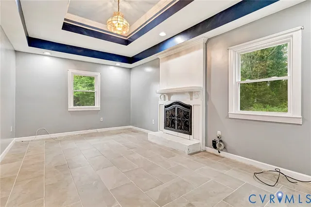a view of an empty room with window and fireplace