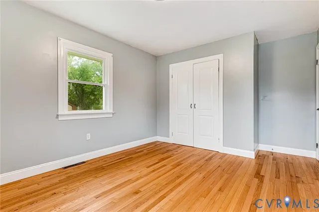 a view of a room with wooden floor and window