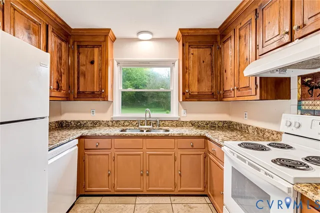 a kitchen with granite countertop a sink stove and cabinets