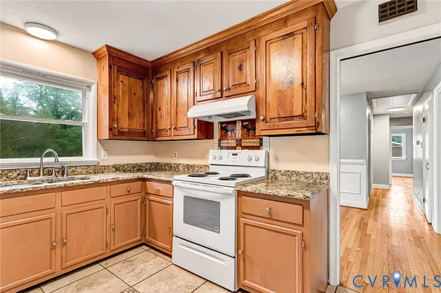 a kitchen with stainless steel appliances granite countertop a stove and white cabinets