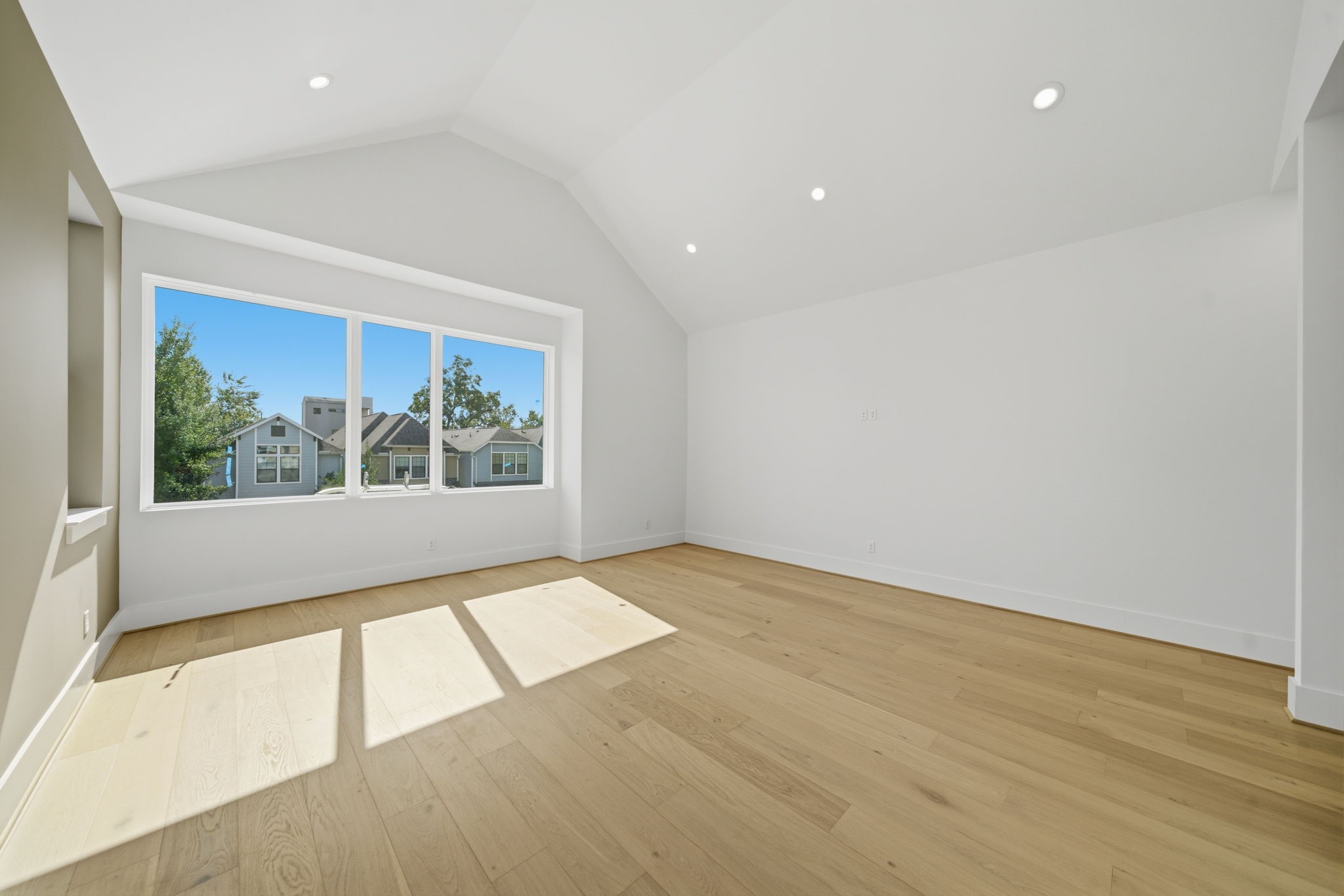1229 Prince Street Houston, TX 77008 - Photo 20 of 32 Another view of the primary bedroom with wood flooring and panoramic windows and natural light (Photo is of a previously completed home. Finishes are subject to change.