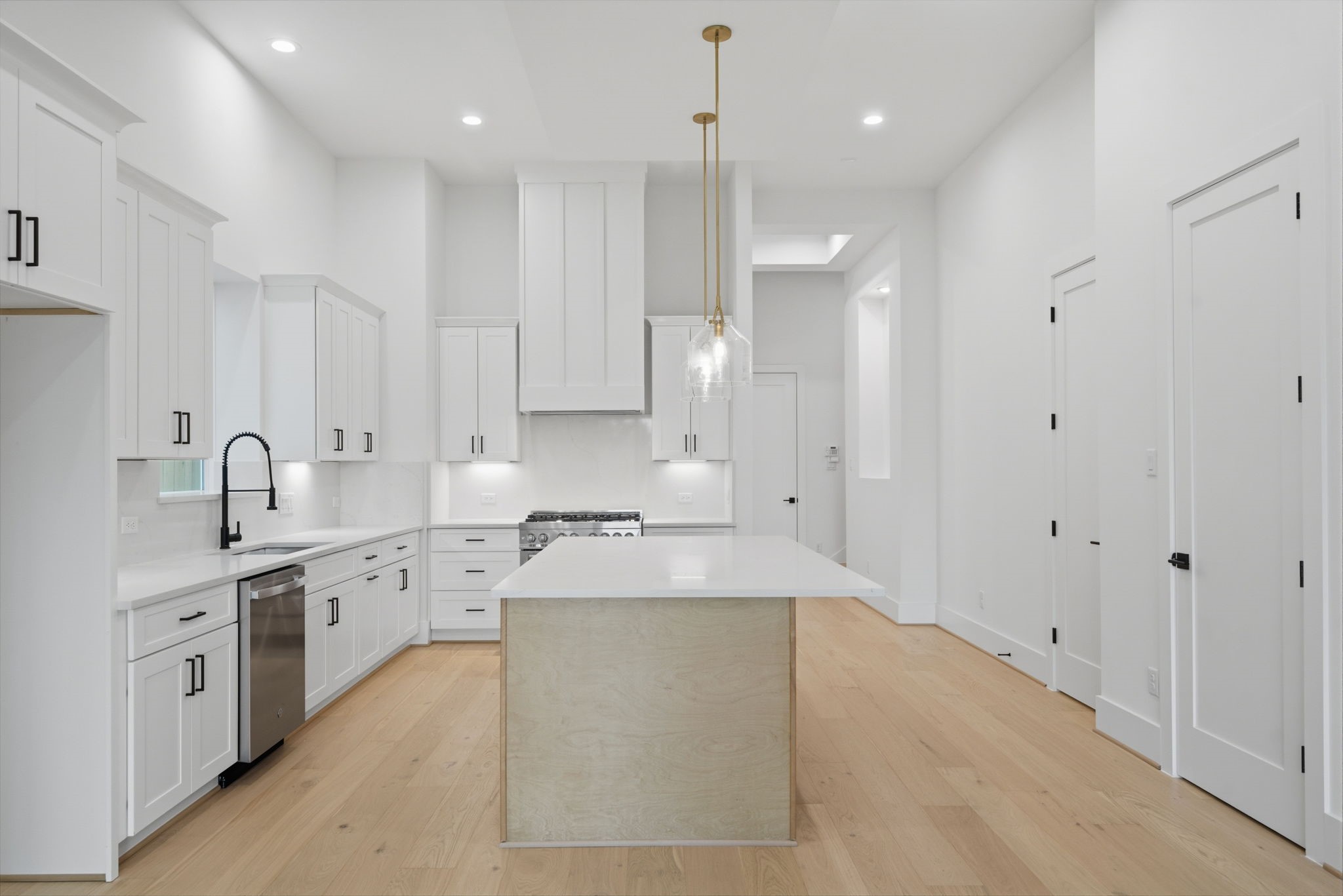 1229 Prince Street Houston, TX 77008 - Photo 3 of 32 Alternate view of spacious island with beautiful quartz countertops and stainless appliances. Large walk-in storage closet and pantry are located on the left. (Photo is of a previously completed home. Finishes are subject to change.)