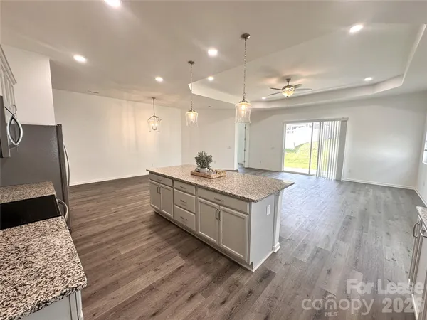 a large kitchen with granite countertop a large counter top a sink a window and stainless steel appliances