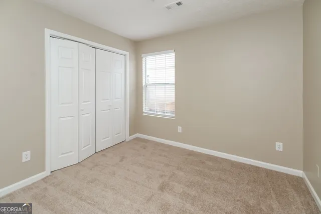 an empty room with windows and closet