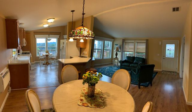 a dining room with couches chairs and wooden floor