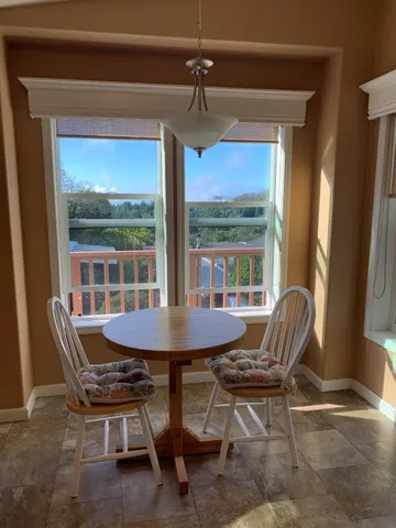 a dining room with furniture a chandelier and wooden floor