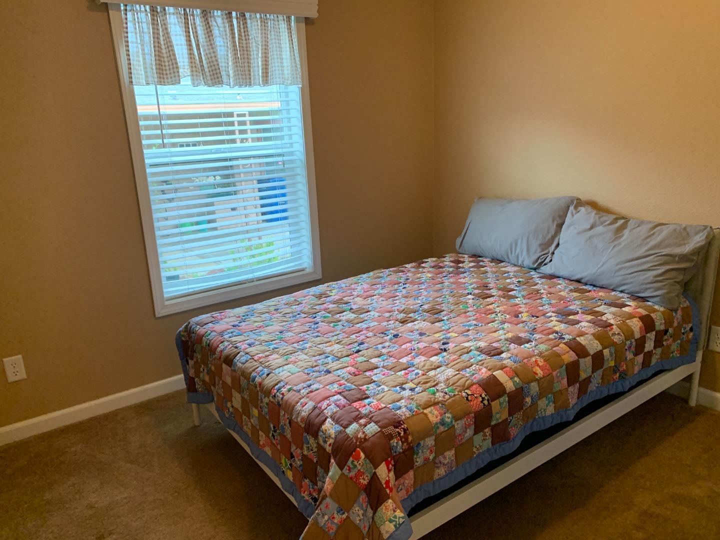 270 Hames Road, Unit 55 Watsonville, CA 95076 - Photo 23 of 53 a bed sitting in a bedroom next to a window