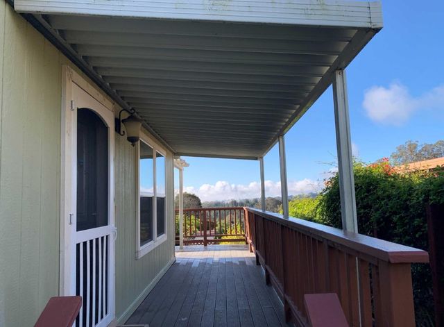 a view of a porch with wooden floor and outdoor seating